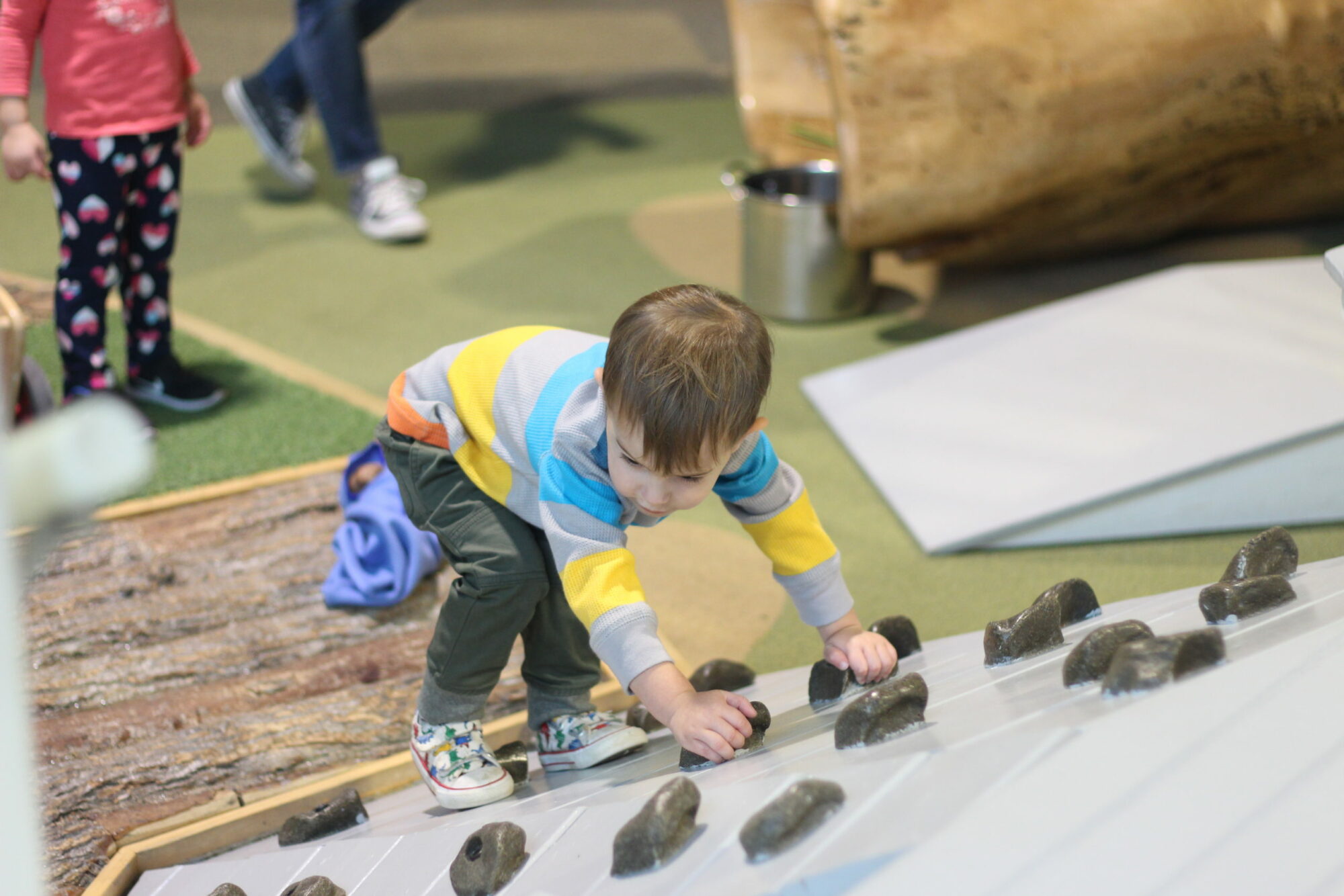 Developing Gross Motor Skills on the climbing ramp in the Infant and Toddler Play Porch Exhibit at the Children's Museum of Southern Minnesota