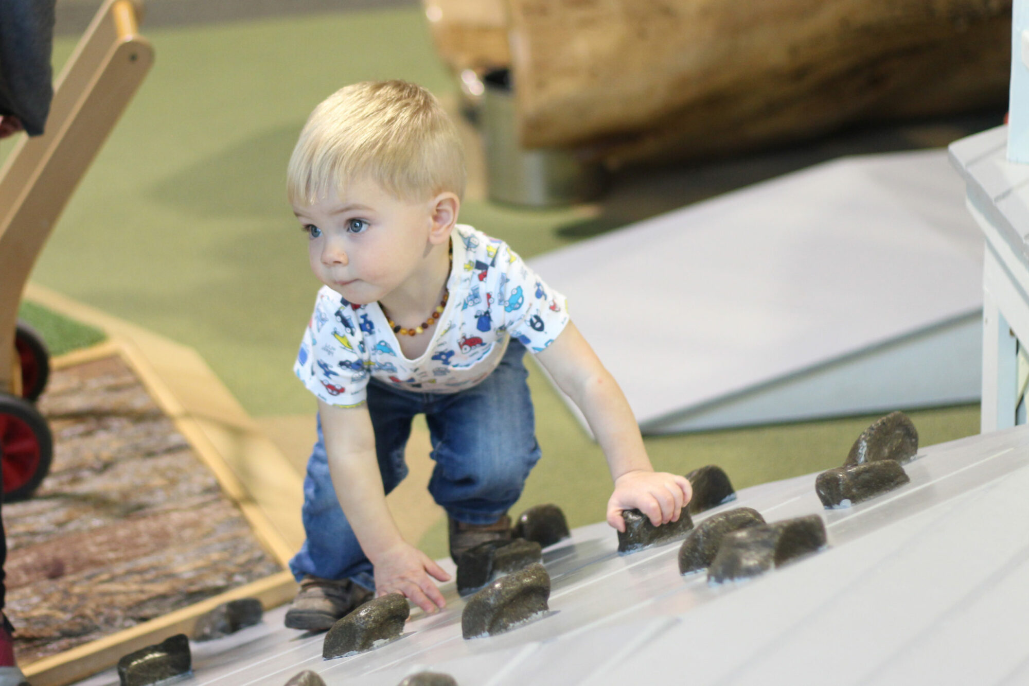 Toddler climbing in the play porch children's museum mankato