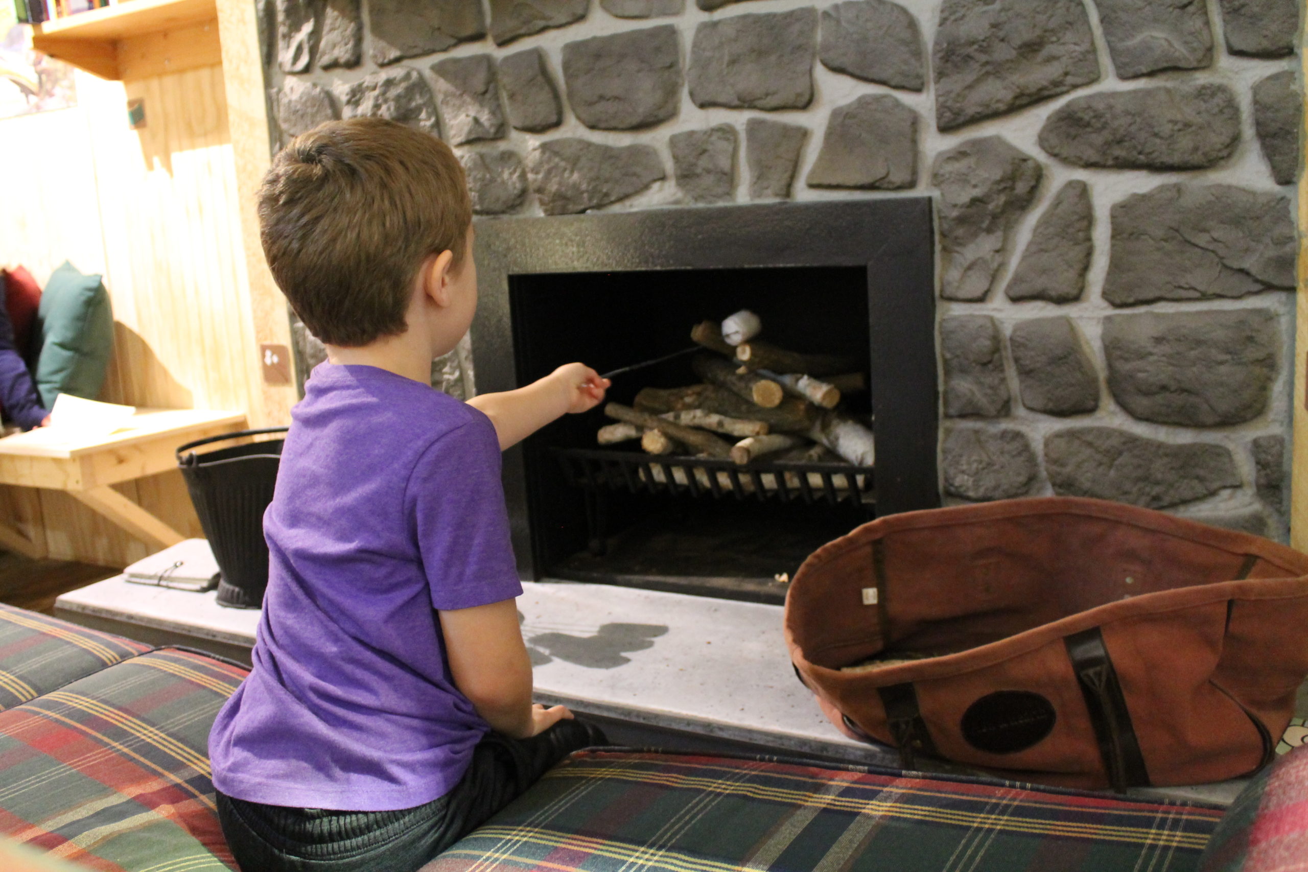 Roasting Marshmallows in the cabin fireplace of a Northwoods Winter Childrens Museum of Southern Minnesota