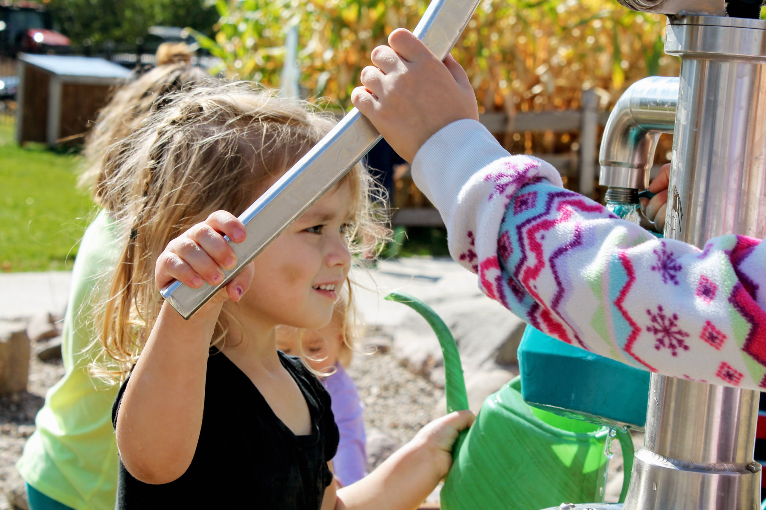 Child-pumping-water-pump-water-play-outdoor-nature-play-area-Dotson-Back-40-Alltech-Farmyard-Childrens-Museum-of-Southern-Minnesota