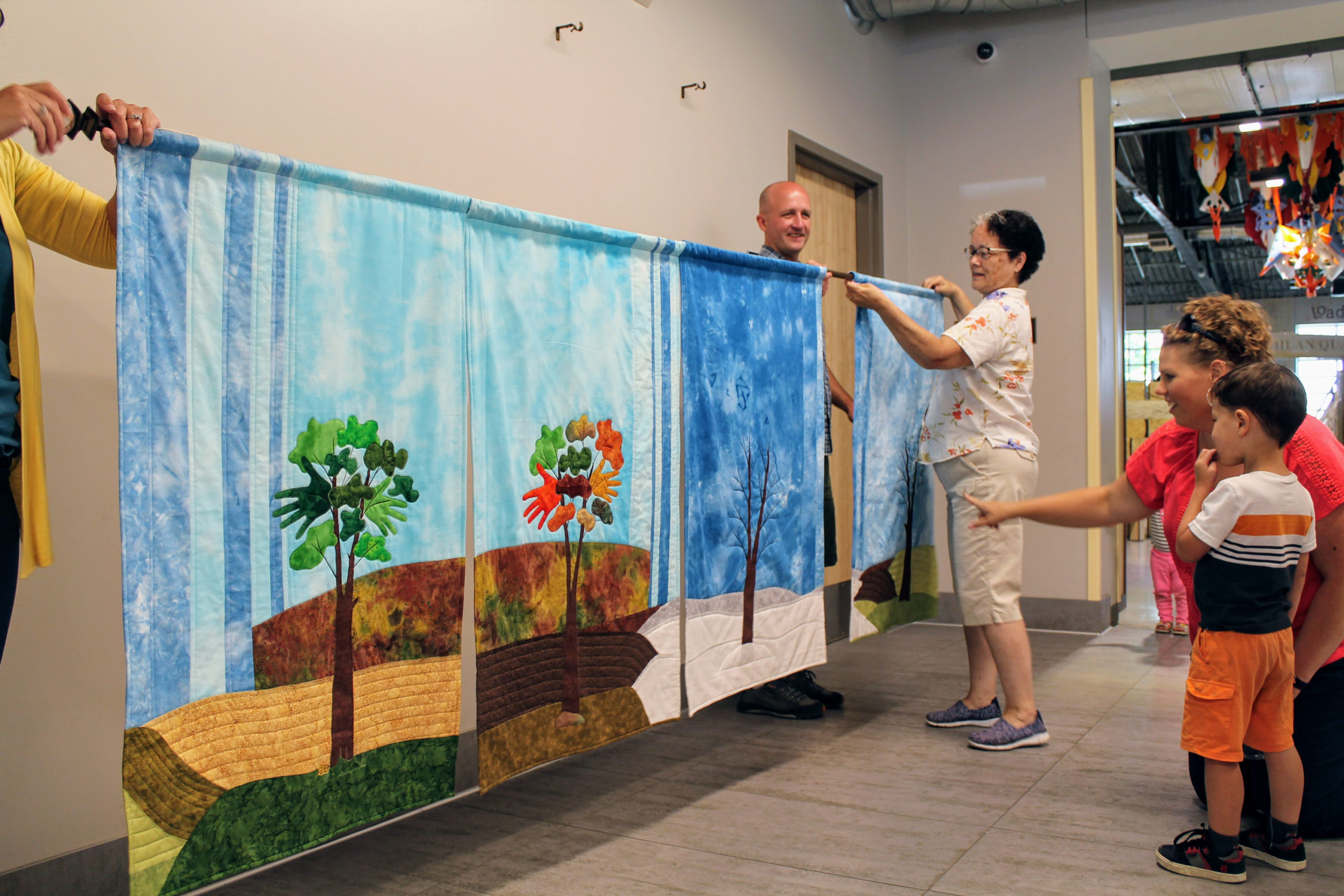 Hanging-the-Four-Seasons-quilt-Dakota-Tribe-Native-American-textile-art-at-the-Childrens-Museum-of-Southern-Minnesota