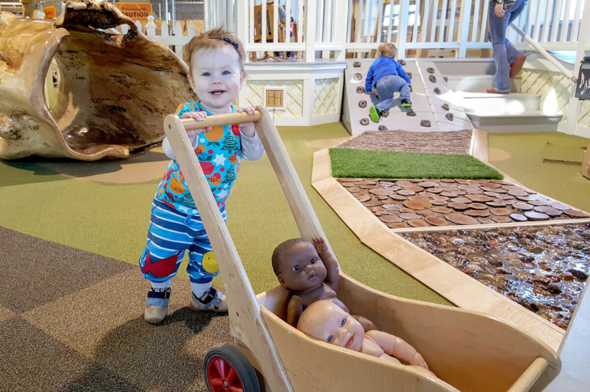 Toddler learning how to walk in the Play Porch at the Children's Museum of Southern Minnesota