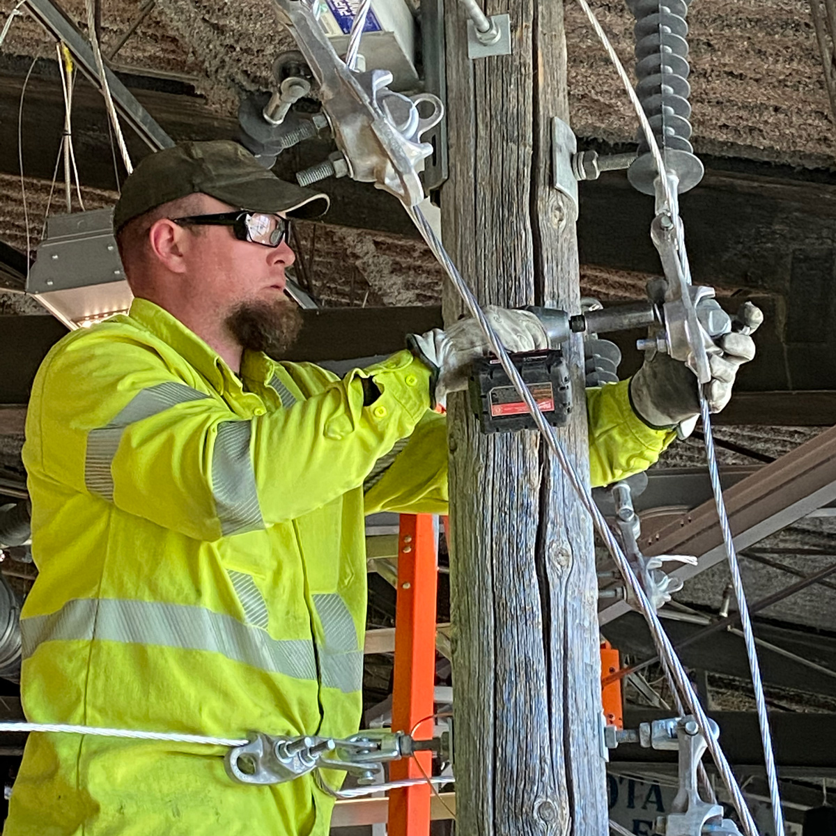 A volunteer installs the power pole in the Energy: Powered by Play Exhibit