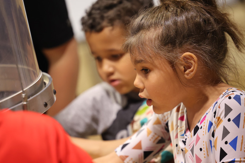 curious girl exploring wind tunnel Children's Museum in Mankato