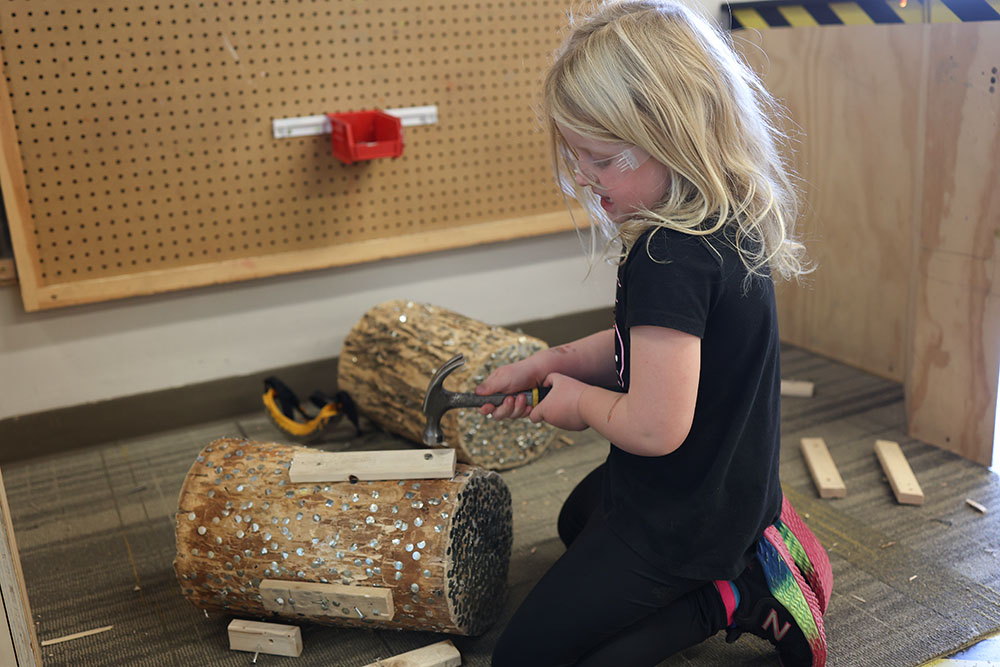 Risky Play girl playing with Hammer at the Children's Museum in Mankato